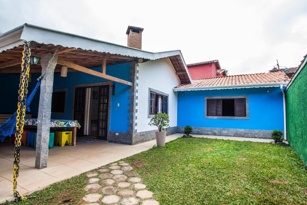 a blue and white house with a yard at Chalés na Montanha Riacho Doce in São Bento do Sapucaí