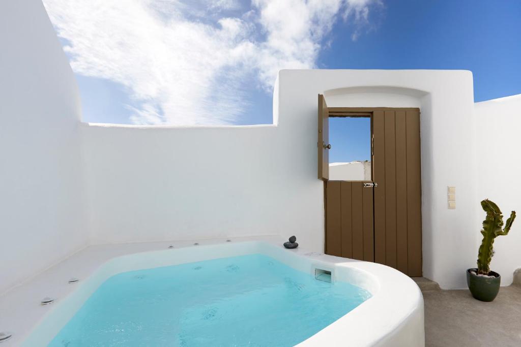 a swimming pool in a white house with a wooden door at The Small Architect's House in Pyrgos