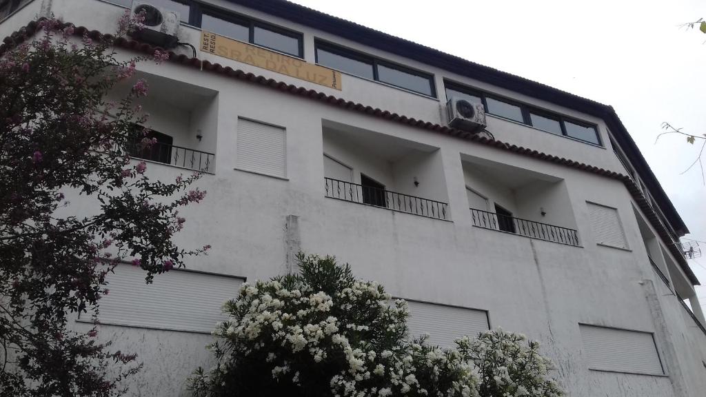 Residencial Retiro Sra. da Luz في بونتي دي ليما: مبنى أبيض بشرفات ونوافذ