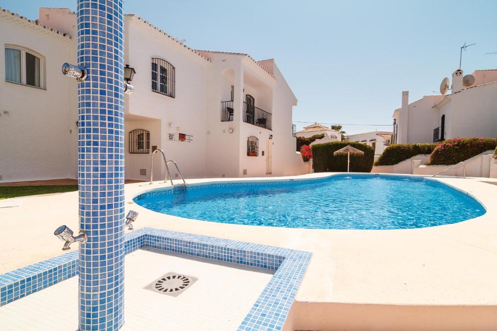 a swimming pool in the middle of a house at Los Pinos 23 Villas Casasol in Nerja