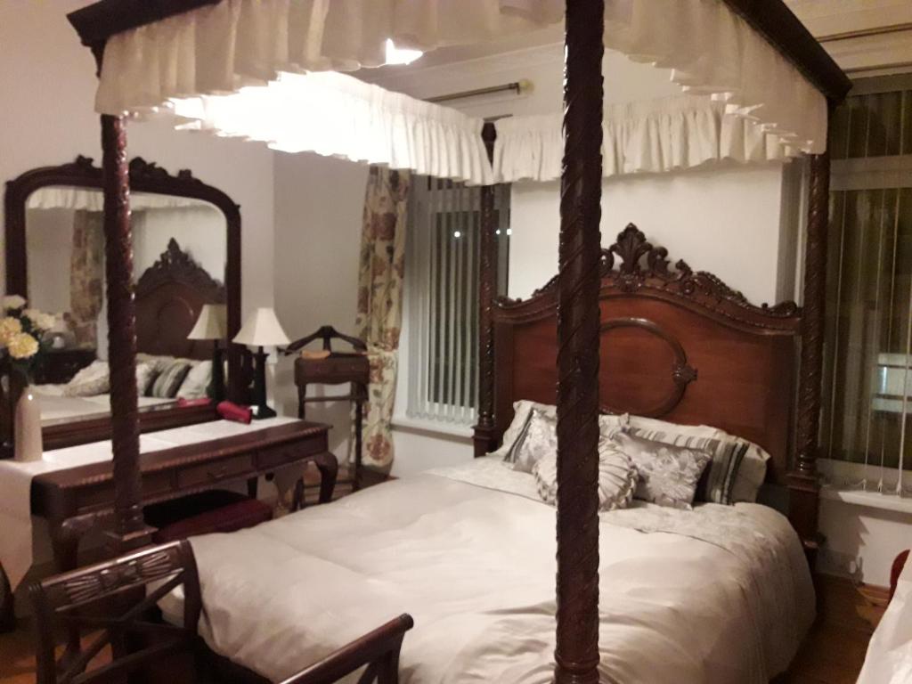 a bedroom with a four poster bed and a piano at Titanic Sailortown Belfast City Centre townhouse in Belfast