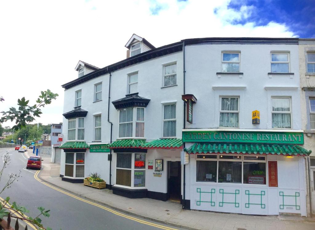 a white building on the corner of a street at Garden Hotel in Bangor