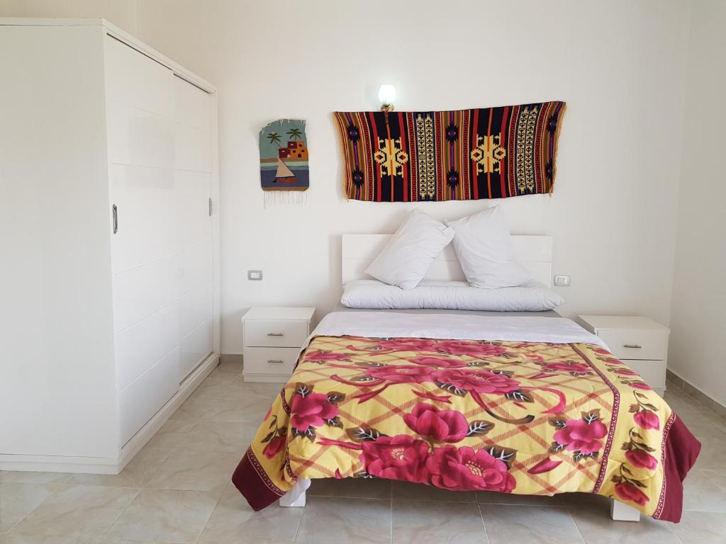 ルクソールにあるLuxor VIP Apartmentsのベッドルーム1室(カラフルな毛布付きのベッド1台付)