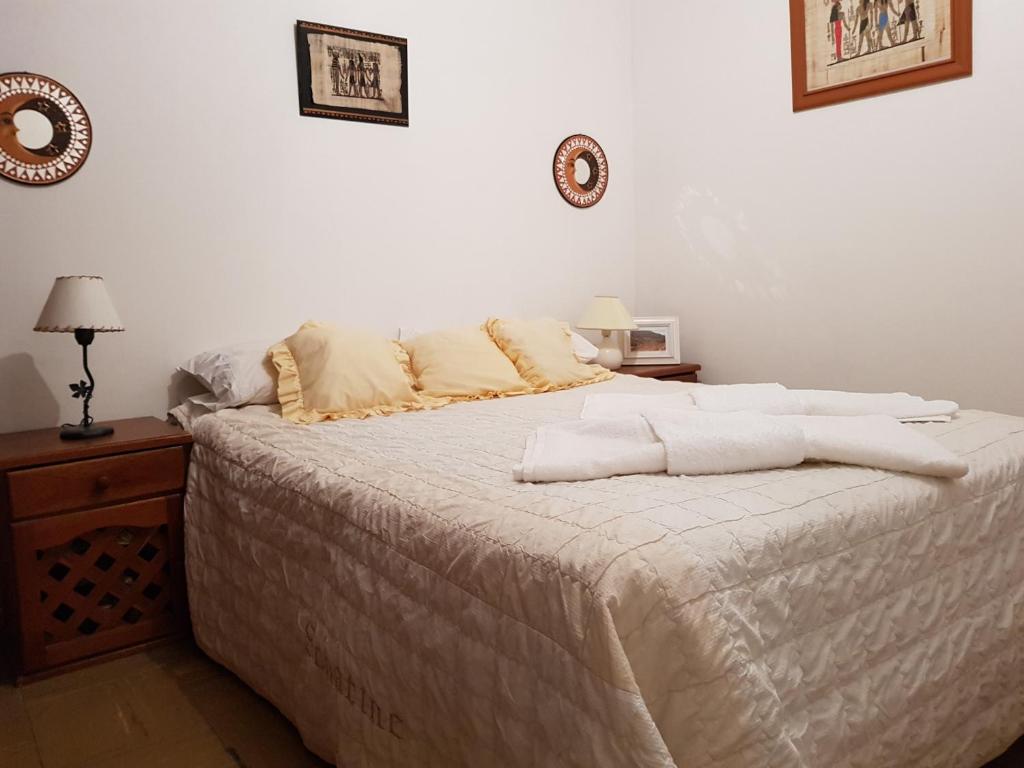 Una cama blanca con sábanas blancas y almohadas. en Departamento Paseo Balcarce en Salta