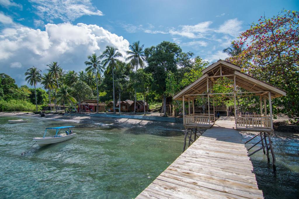 un barco está atracado en un muelle en el agua en Pristine Paradise Dive Resort Una Una en Pulau Unauna