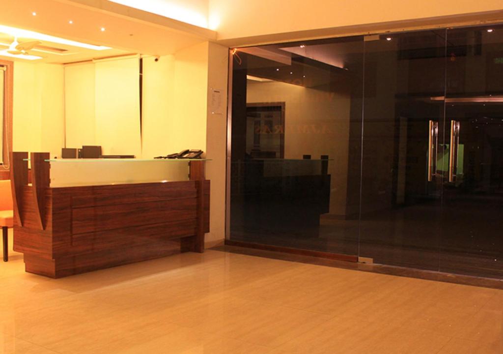 a room with a large glass window and a desk at Hotel Vaikunth By Adamo in Nāthdwāra