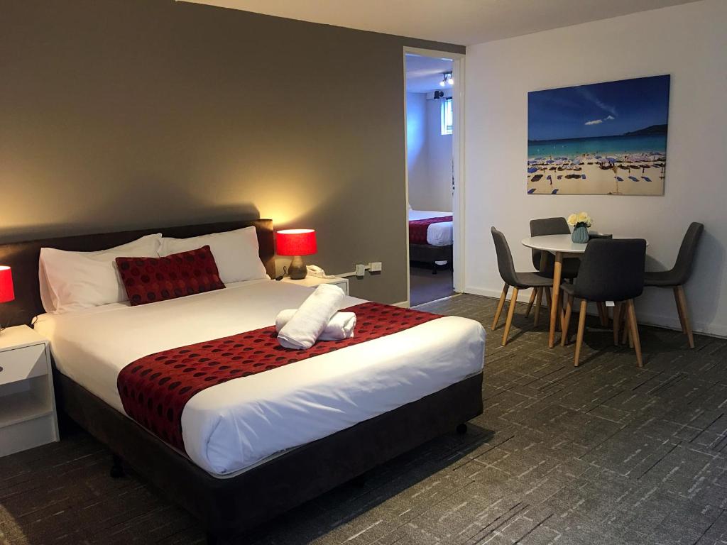 a bedroom with a bed and a table with chairs at Parkdale Motor Inn in Parkdale