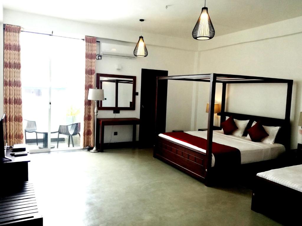 a bedroom with a canopy bed and a window at Hasara Hotel Galle in Galle