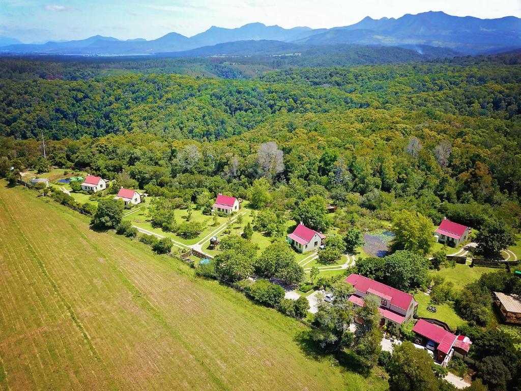 une vue aérienne sur une ferme avec des maisons et des arbres dans l'établissement Forest Edge, à Rheenendal