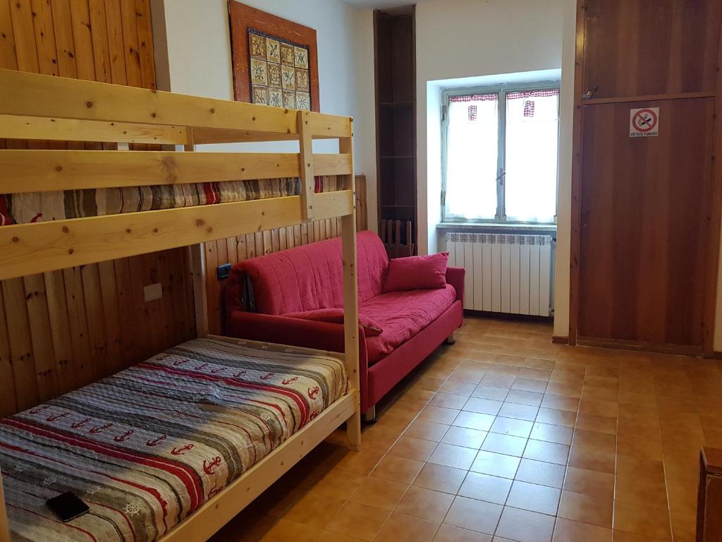 a bedroom with a bunk bed and a couch at monolocale paradiso aremogna in Roccaraso