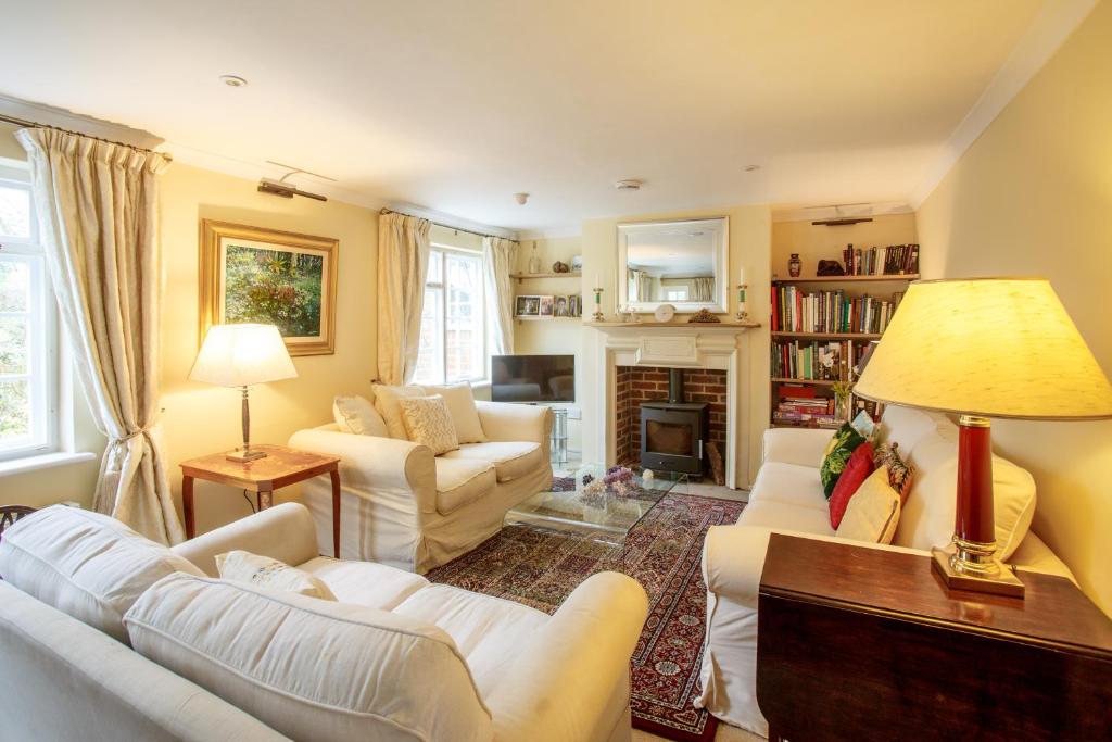 Elle comprend un salon doté d'un mobilier blanc et d'une cheminée. dans l'établissement Jasmine Cottage, à Kelsale
