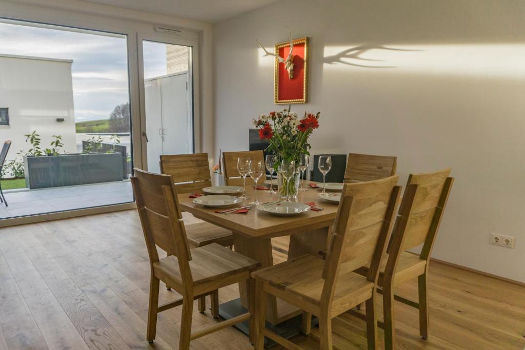 شقة فيلا ريغوليتو في سالزبورغ: غرفة طعام مع طاولة وكراسي خشبية