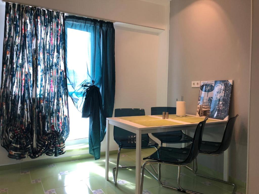 mesa y sillas en una habitación con ventana en Green Apartment 6, en Bucarest