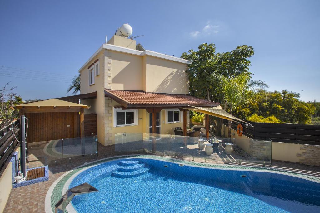 una casa con piscina di fronte a una casa di Ayia Napa Tropical Beach Villa a Ayia Napa