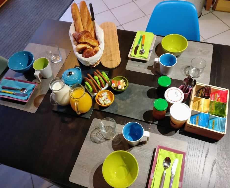 a table with a breakfast of bread and food at Des Km à La Ronde in La Ronde