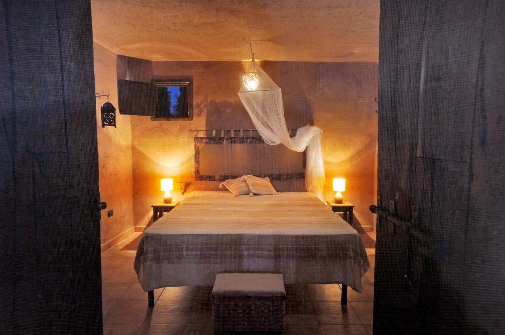 una camera con un grande letto con due luci accese di Uva Rosa a Gallipoli