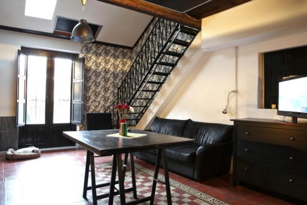 un soggiorno con divano nero e tavolo di Solsicily a Catania