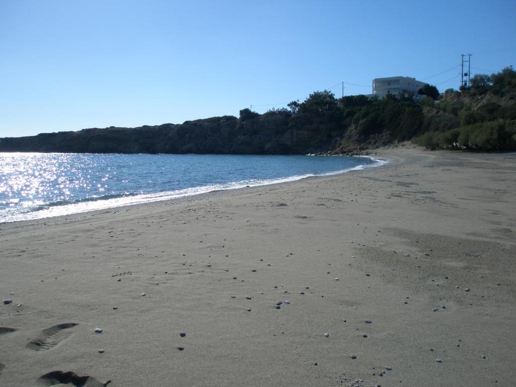 a beach with footprints in the sand next to the water at Avra Palm in Koutsounari