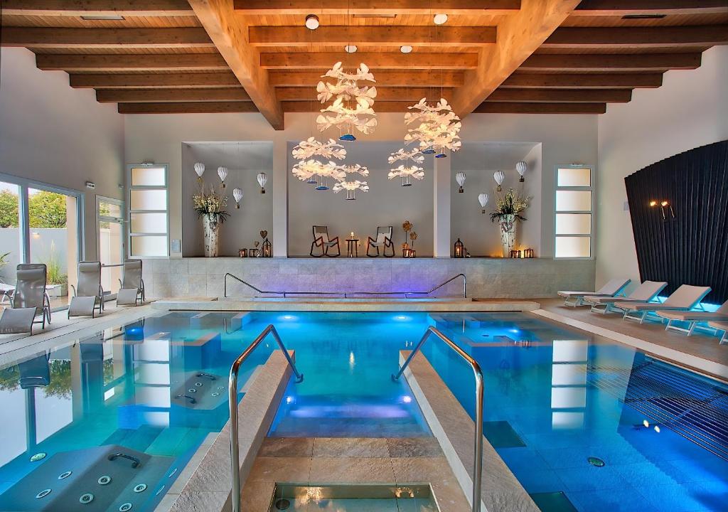 a swimming pool in a house with a chandelier at Hotel Eliseo Terme in Montegrotto Terme