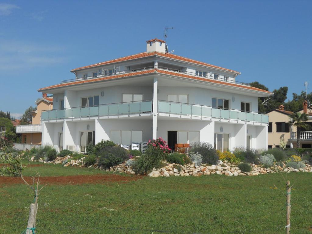 a large white building on top of a green field at Apartments Alen in Umag