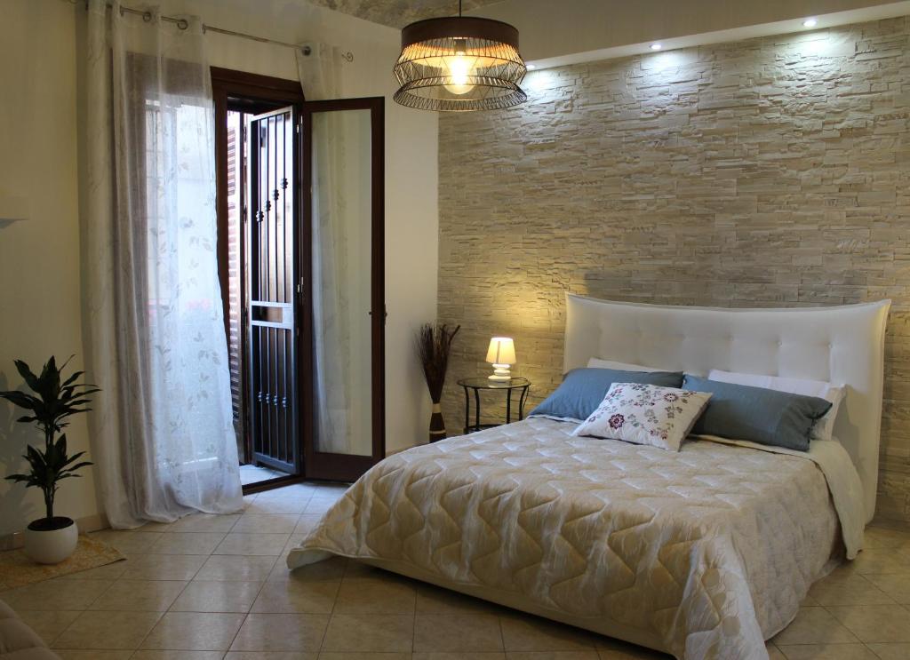 een slaapkamer met een groot bed en een bakstenen muur bij Ai Carrettieri della Cattedrale in Palermo