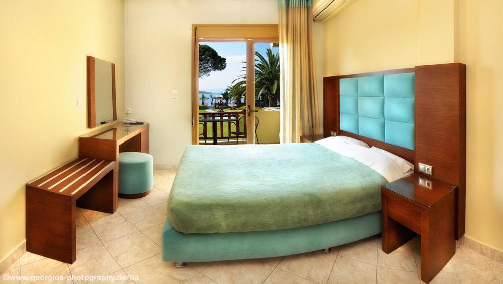 a bedroom with a large bed and a balcony at Vergos Hotel in Vourvourou