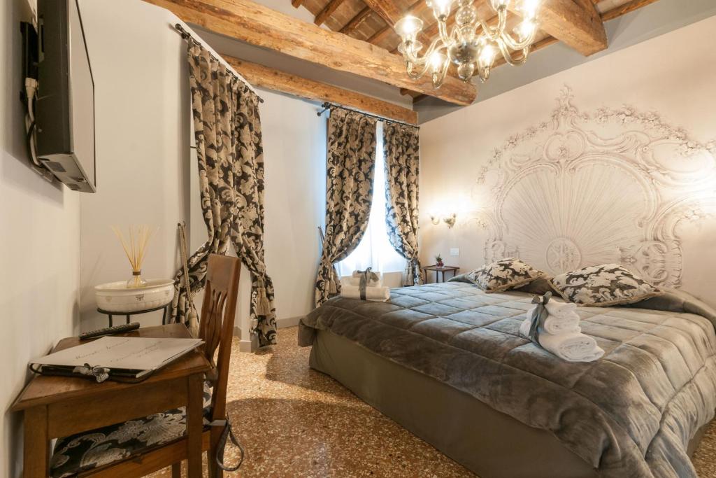 ヴェネツィアにあるSan Marco Luxury apartments Munegheのベッドルーム(ベッド1台、テレビ、シャンデリア付)