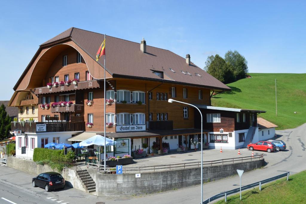 un grand bâtiment brun avec un toit en gambrel dans l'établissement Gasthof zum Bären, à Südern