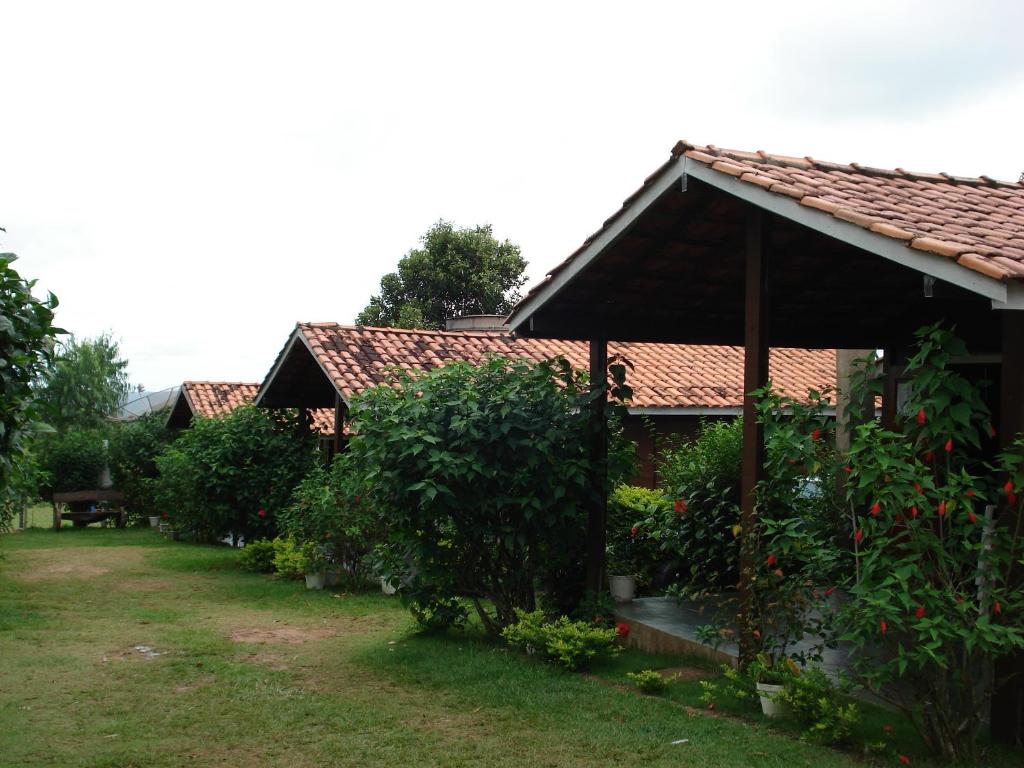 una casa con cenador y algunos arbustos en Pousada Jardim da Chapada, en Chapada dos Guimarães