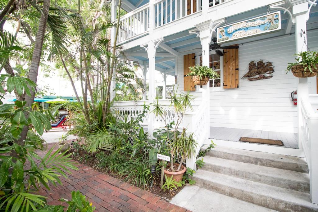 a white house with palm trees and stairs at Key West Harbor Inn - Adults Only in Key West
