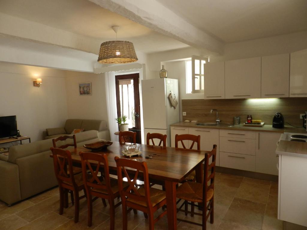 a kitchen and dining room with a wooden table and chairs at La Maison Péano in Gassin