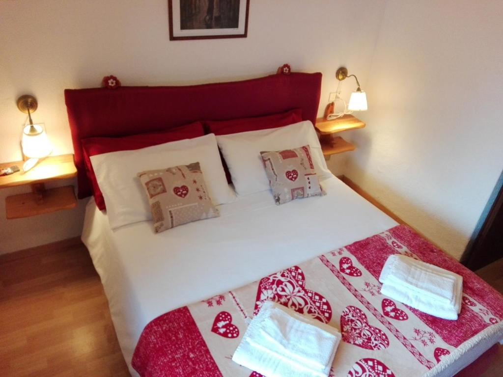 a bedroom with a bed with a red headboard and pillows at Ski-Garden in Mezzana