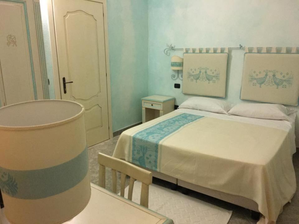 a small bedroom with a bed and a table at Hotel Monreale in Sardara