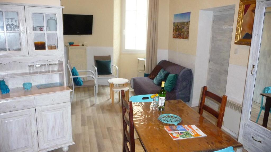 cocina y sala de estar con mesa y sillas en Le Perigord, en Sarlat-la-Canéda
