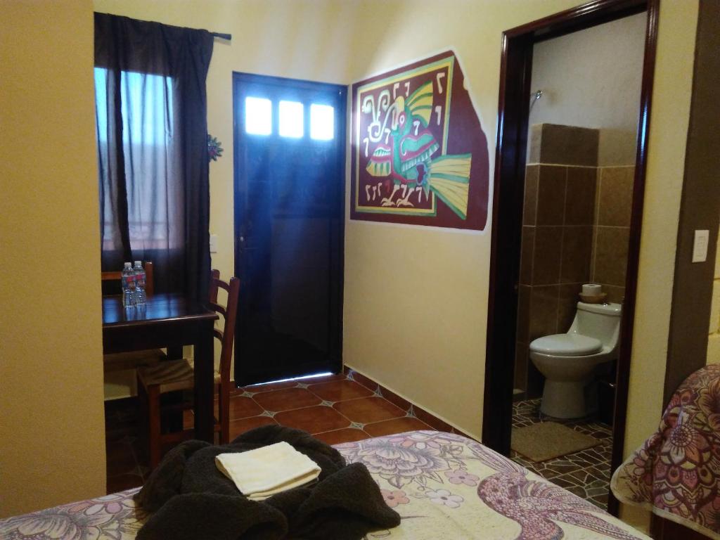 a room with a bed and a bathroom with a toilet at El Sueño de Quetzalcoatl in San Juan Teotihuacán
