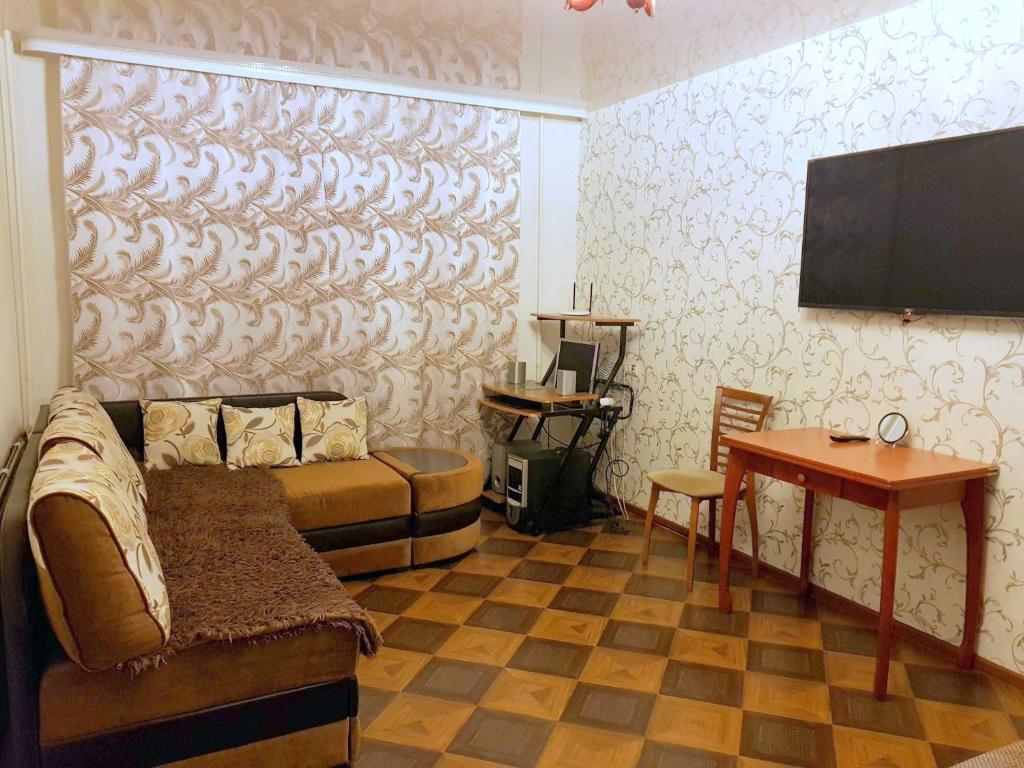 ウシンスクにあるАпартаменты на Приполярной, 10Аのベッド、テレビ、テーブルが備わる客室です。