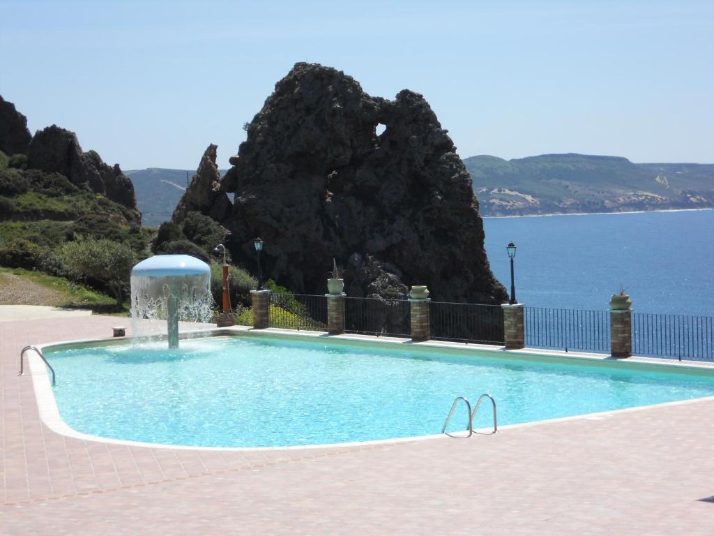 a swimming pool with a view of the ocean at Villa Le Conchiglie in Nebida