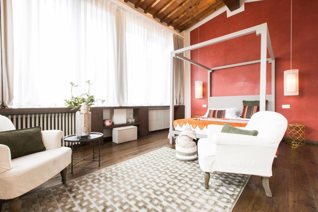 ein Schlafzimmer mit einem Bett und zwei weißen Stühlen in der Unterkunft Canto degli Scali in Florenz