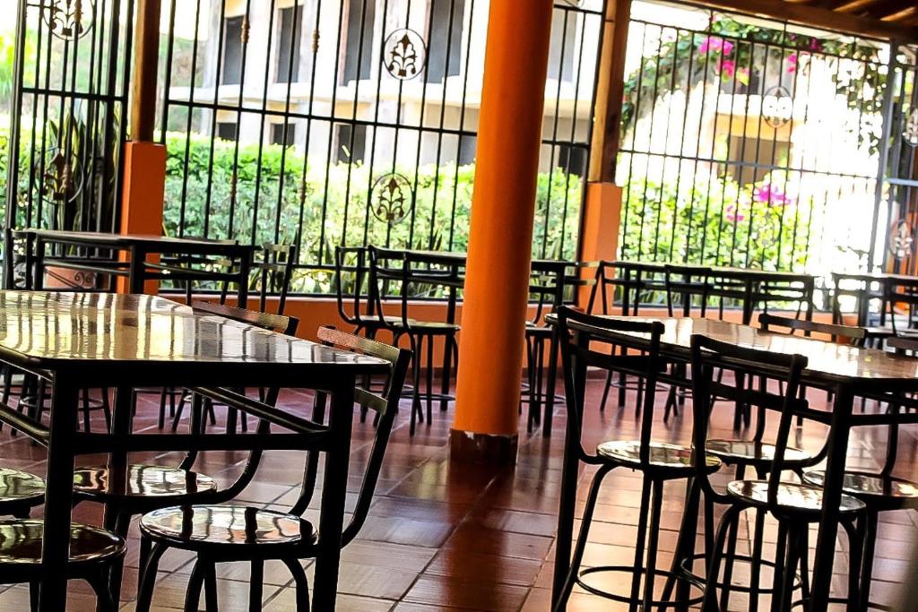 restauracja ze stołami i krzesłami oraz witrażami w obiekcie Casa Campestre Las Nieves w mieście San Gil
