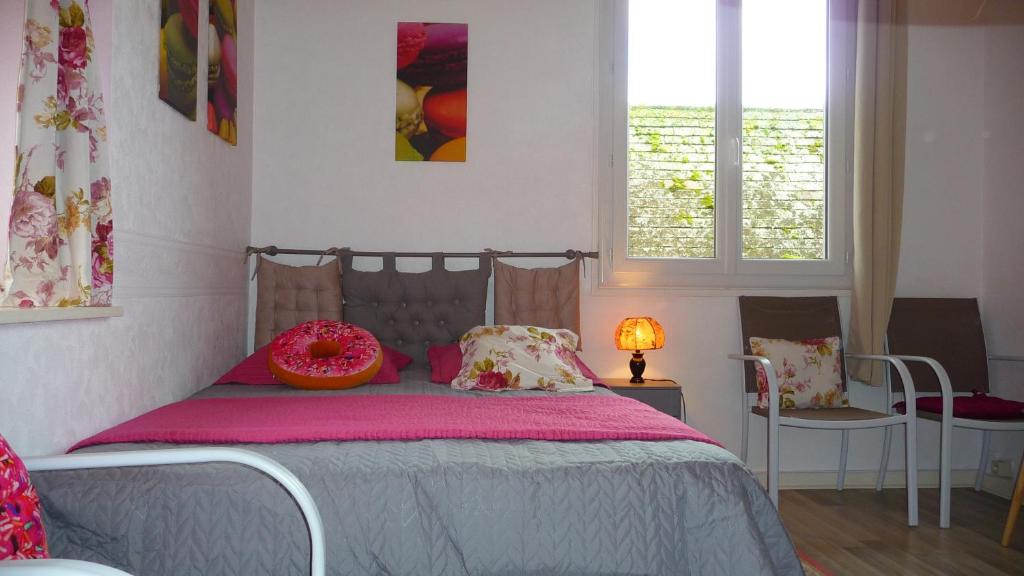 - une chambre avec un lit avec une couverture rose et 2 chaises dans l'établissement La Bonbonnière, à Sarlat-la-Canéda