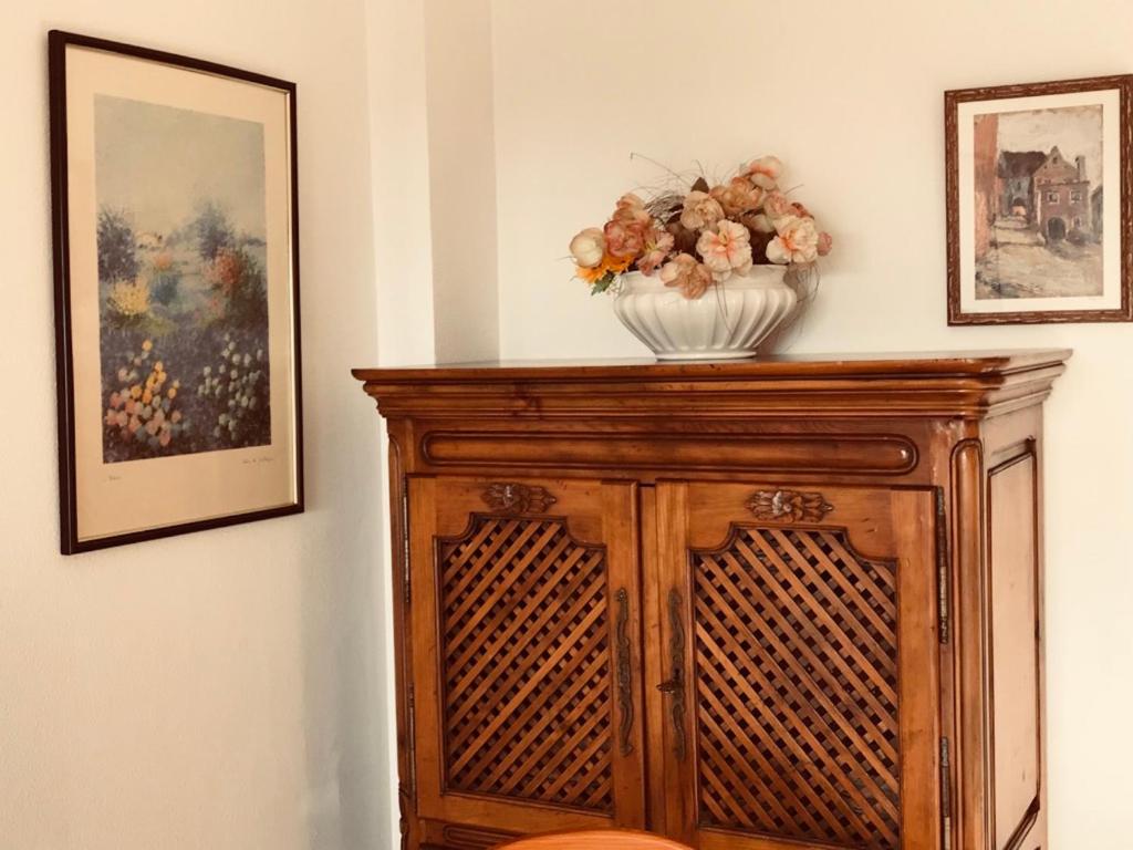 a vase of flowers on top of a wooden cabinet at Cala Azul 304-306 Tamarit in Tamarit