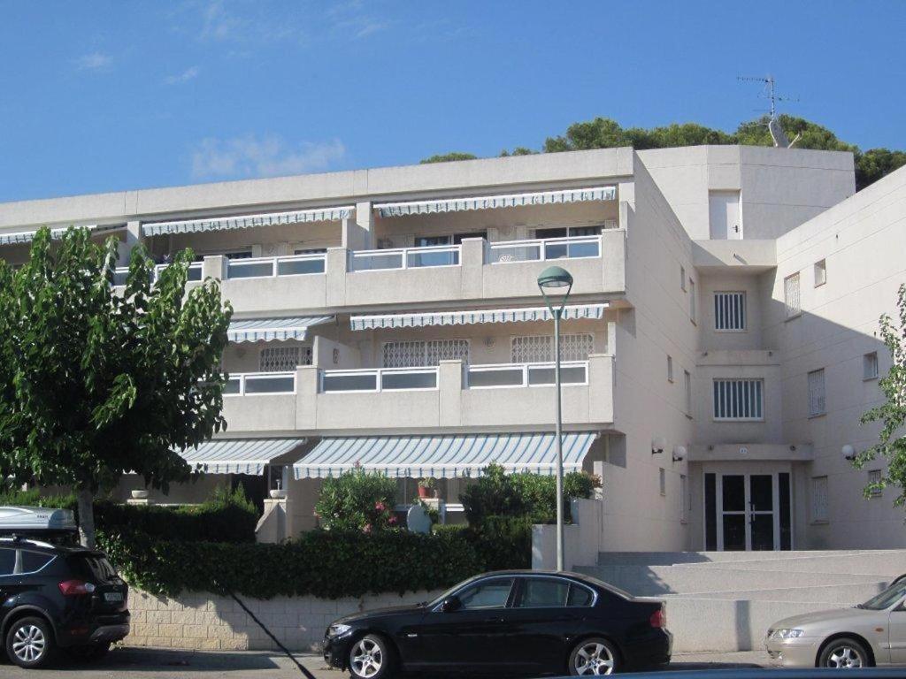 a large building with cars parked in front of it at Cala Azul 304-306 Tamarit in Tamarit