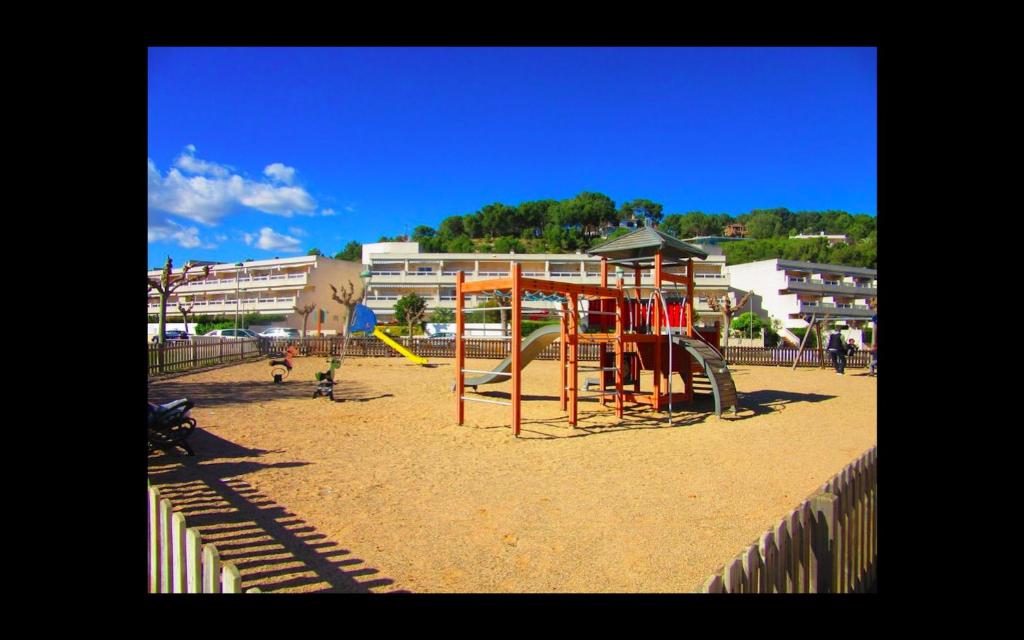 a playground with a swing set in the sand at Cala Azul 304-306 Tamarit in Tamarit