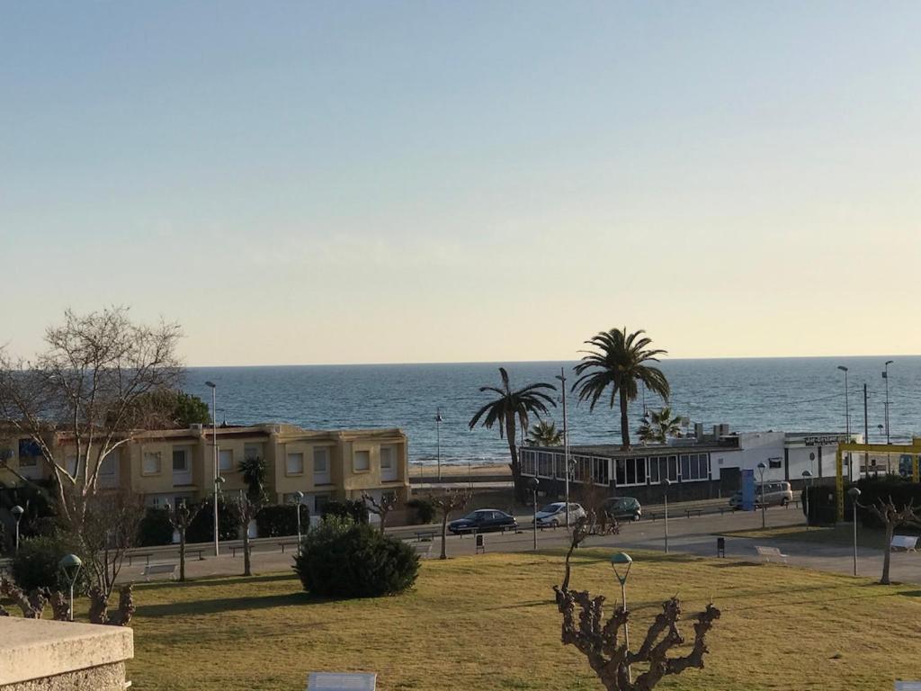 a view of the ocean with buildings and palm trees at Cala Azul 304-306 Tamarit in Tamarit