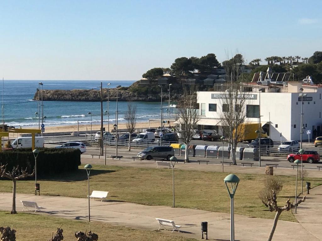 a parking lot next to a beach with cars parked at Cala Azul 304-306 Tamarit in Tamarit