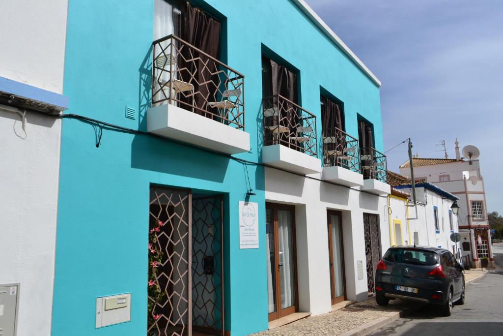 a blue building with a car parked on a street at Alvor Ar de Mar in Alvor