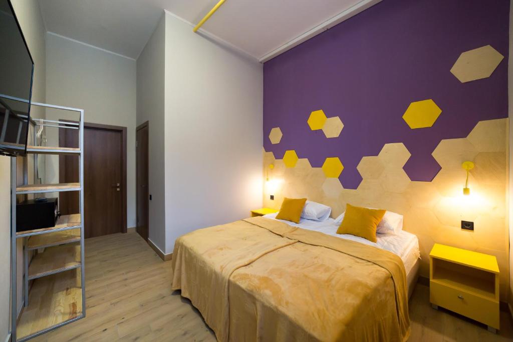 キーウにあるHOTEL Bee Stationの紫の壁のベッドルーム1室(ベッド1台付)