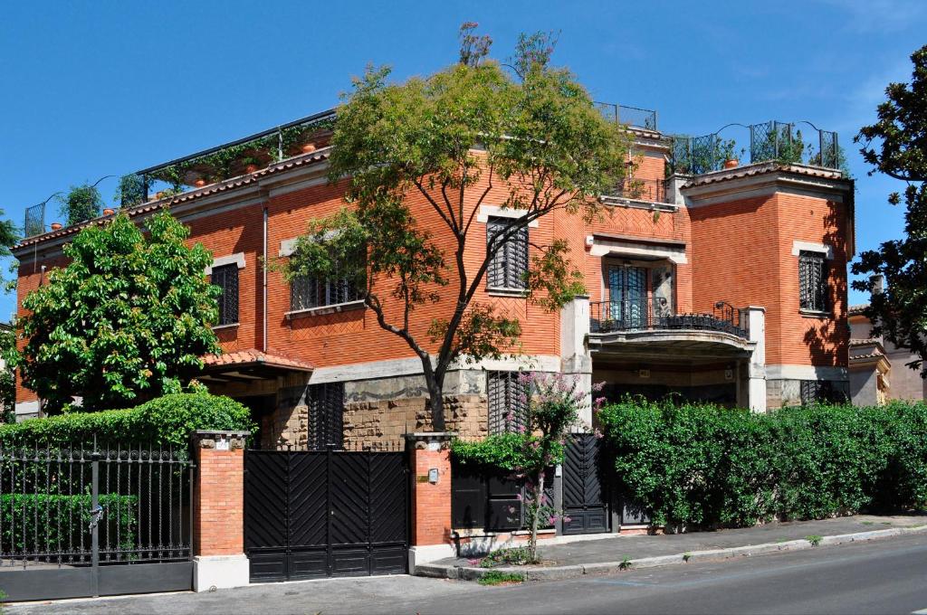 a red brick building with a black gate at Suite Oriani in Rome
