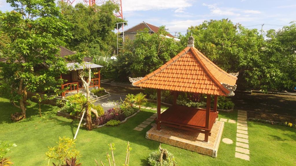 a gazebo with an orange roof in a yard at Mulia Home Stay in Nusa Dua