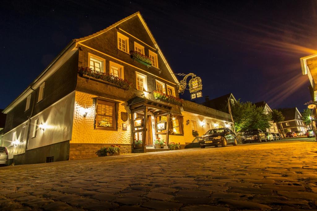 a cobblestone street in front of a building at night at Feste Neustadt in Bergneustadt